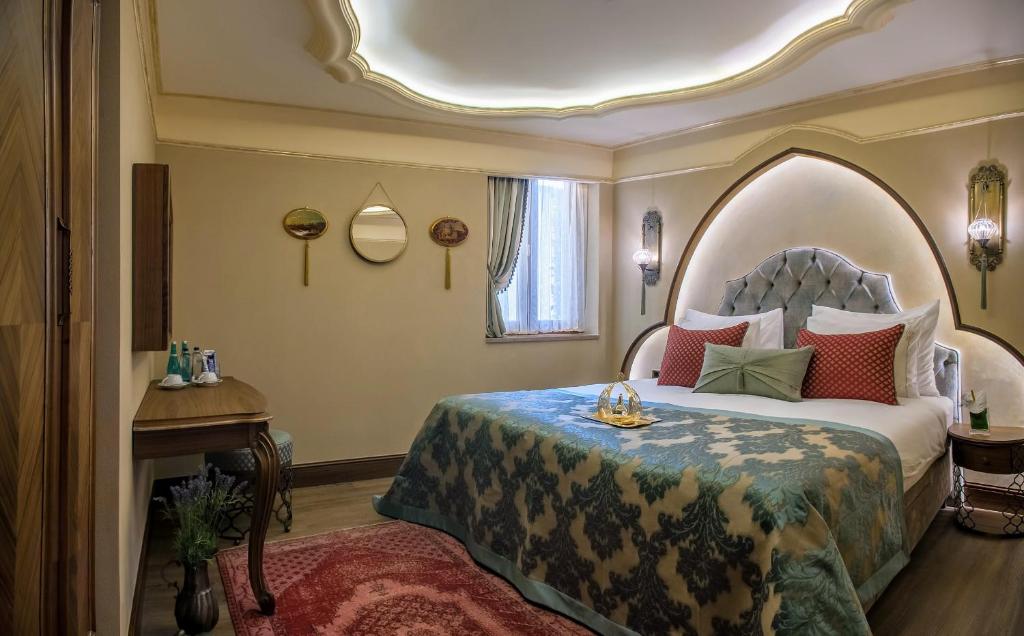 a bedroom with a bed and a table and a window at Romance Istanbul Hotel Boutique Class in Istanbul
