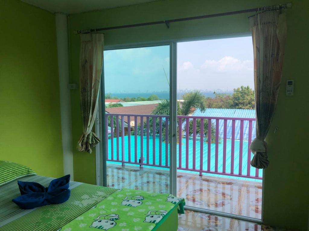 a bedroom with a window with a view of a balcony at Bann Pa Su (บ้านป้าสุ) in Ko Larn