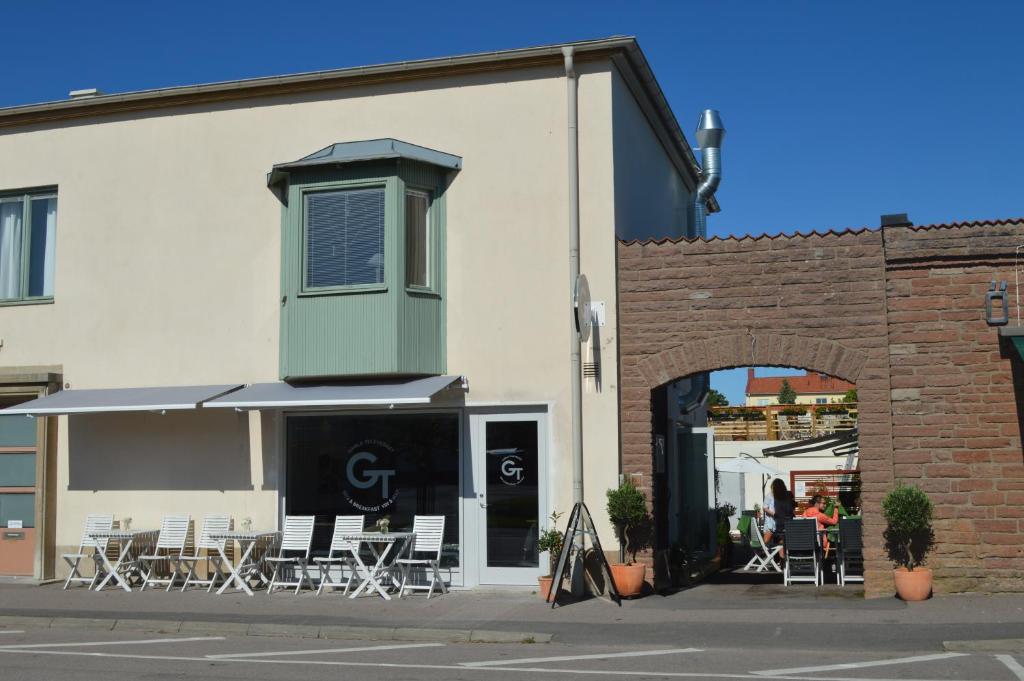 a building with tables and chairs and an umbrella at Gamla Televerket B&B in Borgholm