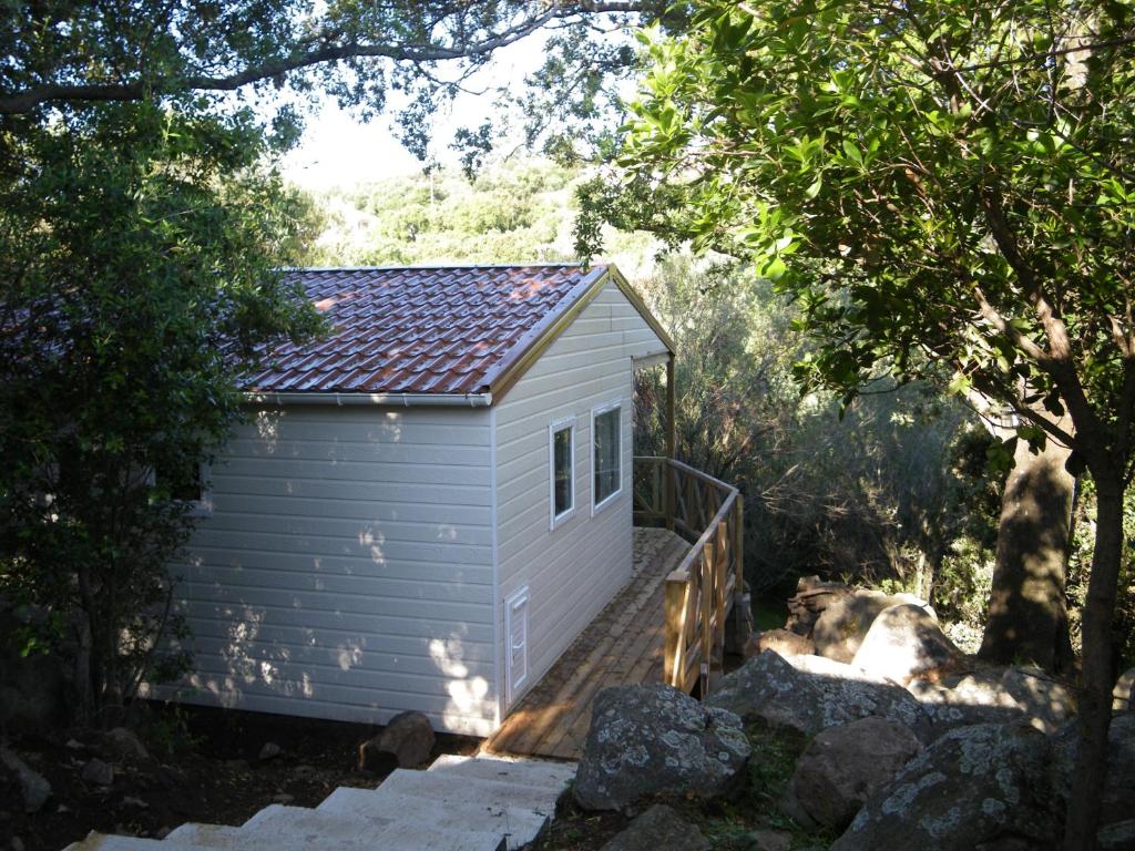 Un petit bâtiment blanc est accessible par un escalier. dans l'établissement Domaine de la Testa, à Sainte-Lucie de Porto-Vecchio