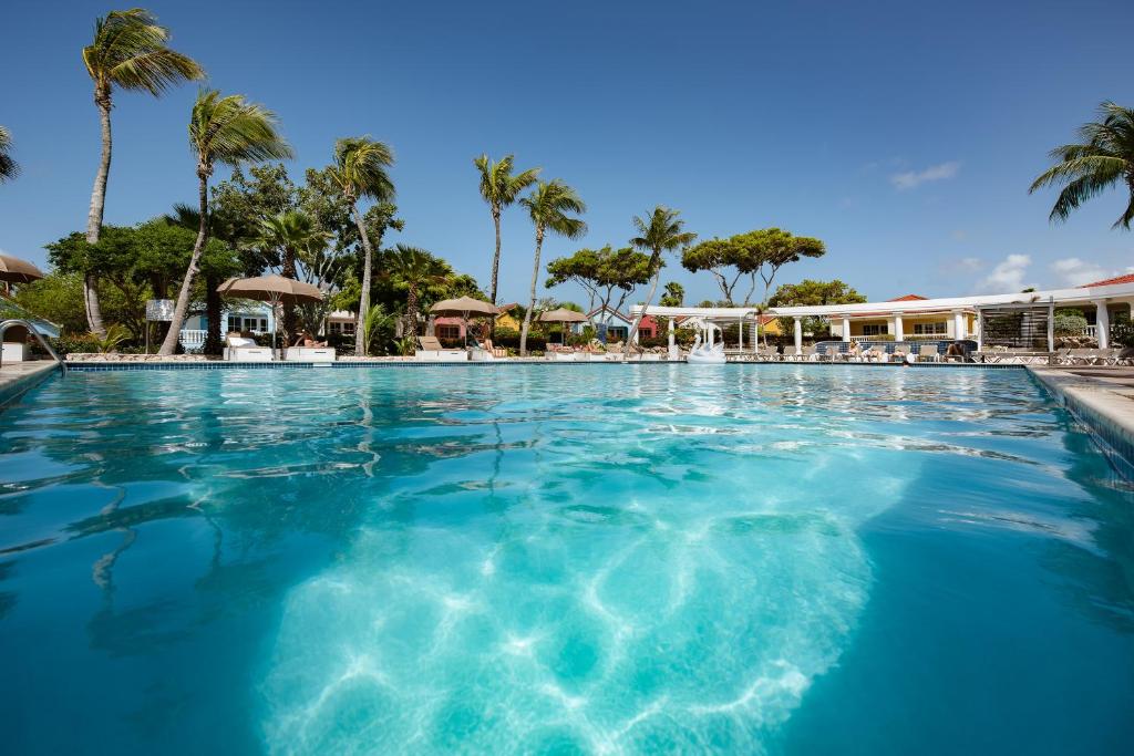 een zwembad in een resort met palmbomen bij Livingstone Jan Thiel Resort in Willemstad