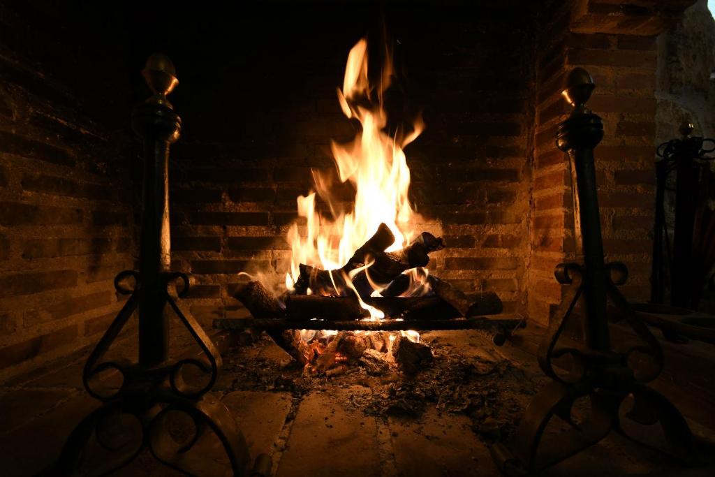Un horno de ladrillo con fuego. en El Rincón de Pilar Disfruta de tu escapada rural disfruta de tu casa, en Fuentemilanos