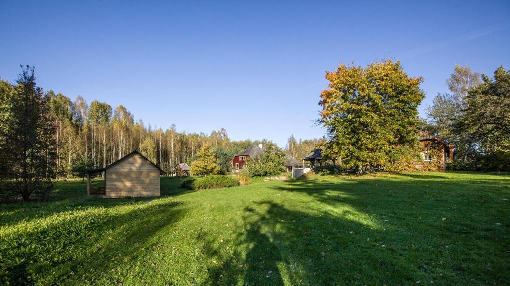 a large grassy field with a house in the background at Dubingiai summerhouse in Dubingiai