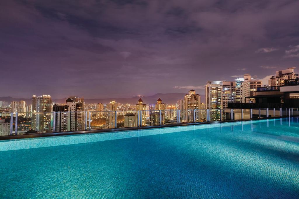 An infinity-style rooftop pool overlooking Kuala Lumpur at night.