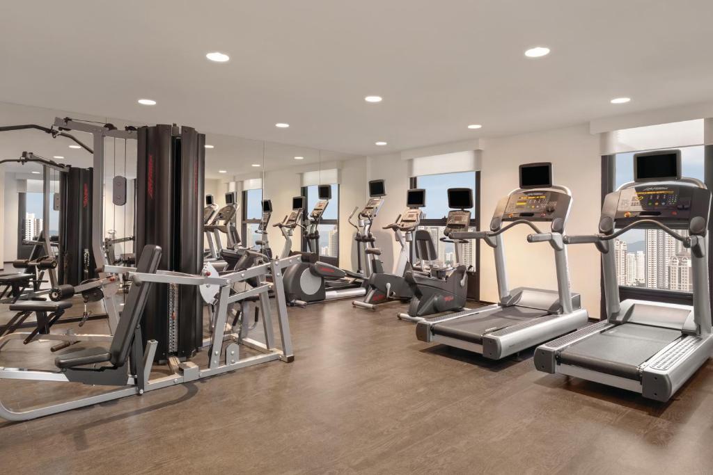 A bright fitness room with treadmills, cardio machines, and strength equipment.