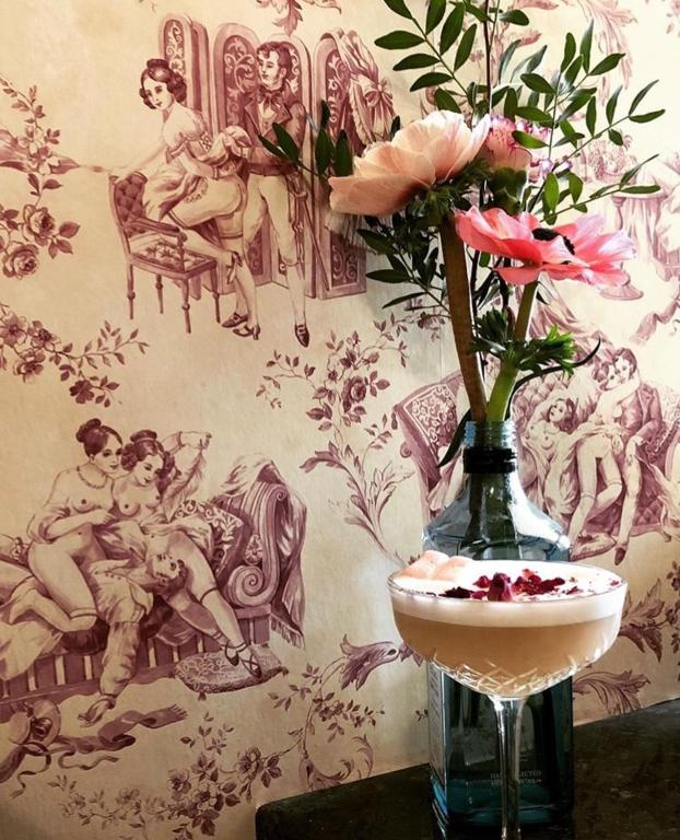 a vase with a flower and a drink on a table at Hôtel Le G (ex Le Genève) in Nice