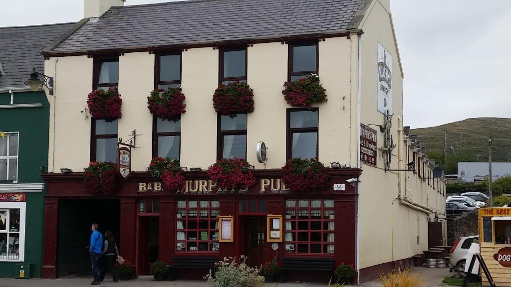 a man standing in front of a building at Murphy's Pub and Bed & Breakfast in Dingle