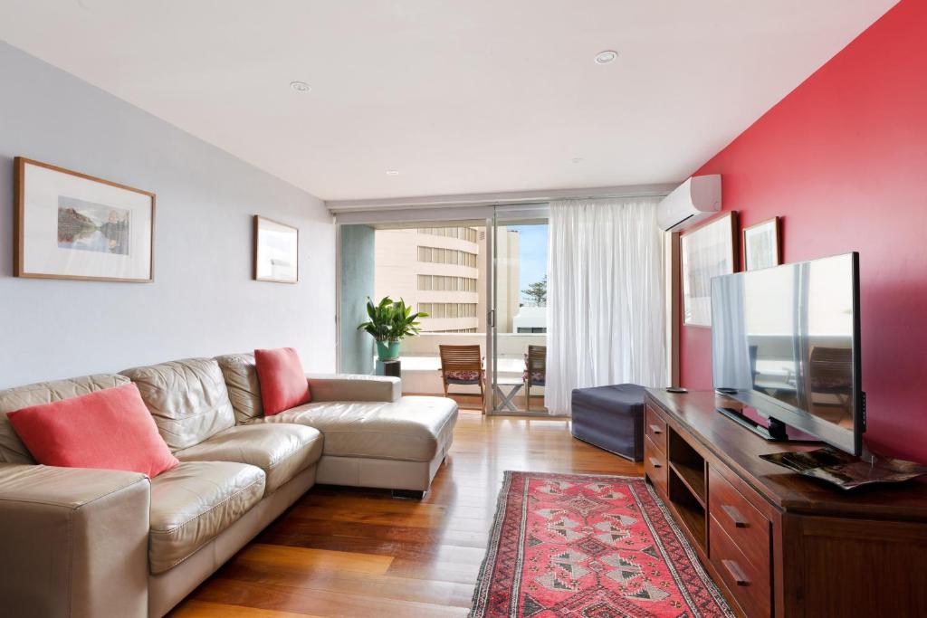 a living room with a couch and a flat screen tv at manlybeachonline.com713 At The Beach in Sydney