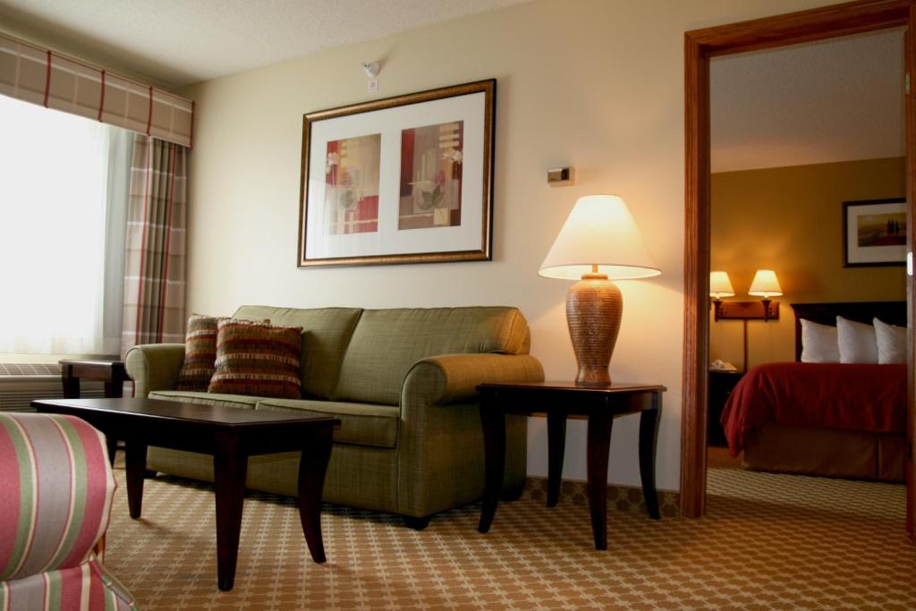 a living room with a couch and a bed at Country Inn & Suites by Radisson, Lincoln North Hotel and Conference Center, NE in Lincoln