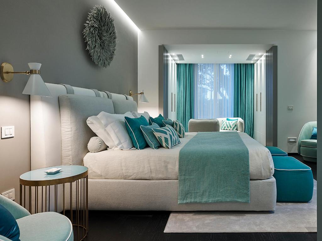 a bedroom with a large bed and a couch at Hotel Byron in Forte dei Marmi