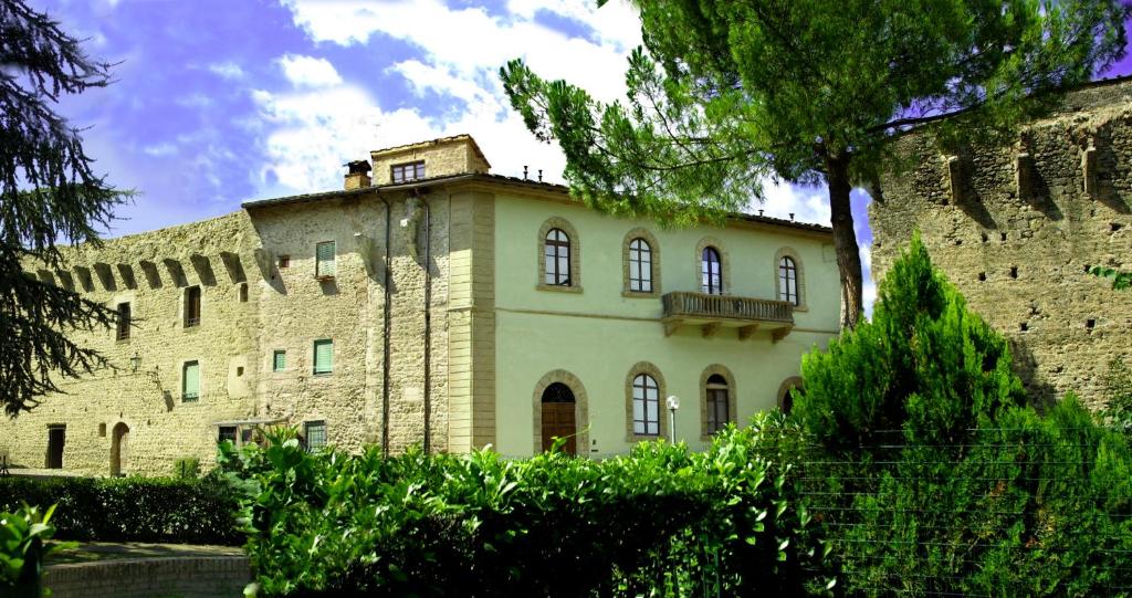 un gran castillo con un árbol delante de él en Palazzo Alle Mura, en Staggia