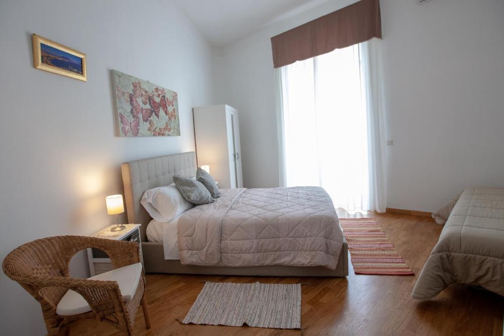 1 dormitorio con 1 cama, 1 silla y 1 ventana en Garibaldi House Apartment, en Nápoles