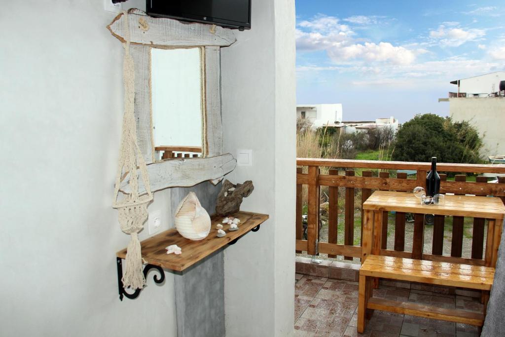 a room with a balcony with a television and a bench at Christos studios and family apartments in Rhodes Town