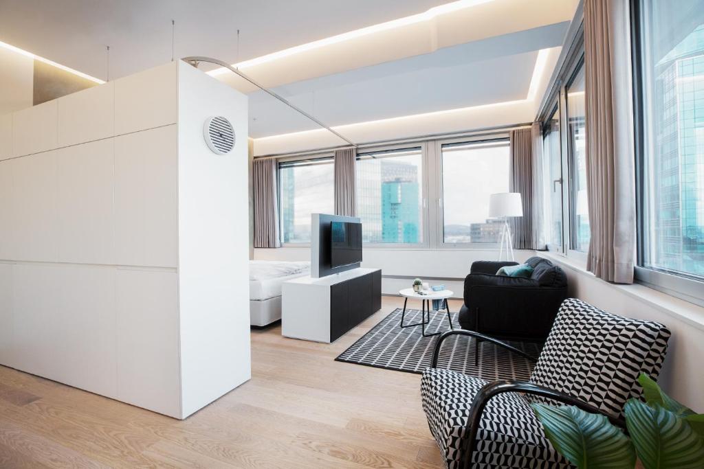 uma sala de estar com um sofá e uma televisão num quarto em PhilsPlace Full-Service Apartments Vienna em Viena