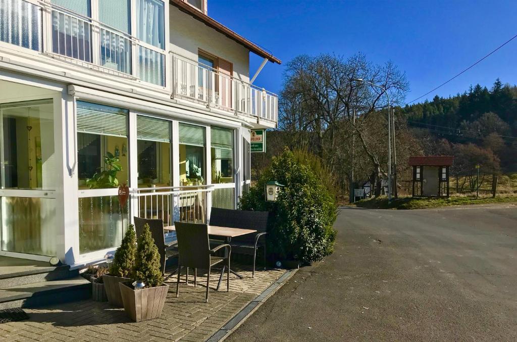 une table et des chaises à l'extérieur d'une maison dans l'établissement Gasthaus Zur Hardtmühle, à Alsfeld