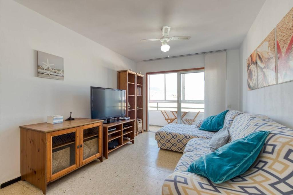 a living room with a couch and a flat screen tv at Apartment Claveles 2 in Telde