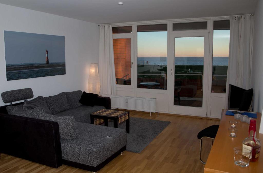 a living room with a couch and a table at 129 - Ferienwohnung am Südstrand in Wilhelmshaven