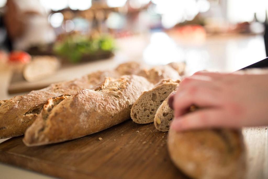 eine Gruppe Brotlaibe auf einem Schneidebrett in der Unterkunft Comwell Borupgaard in Snekkersten