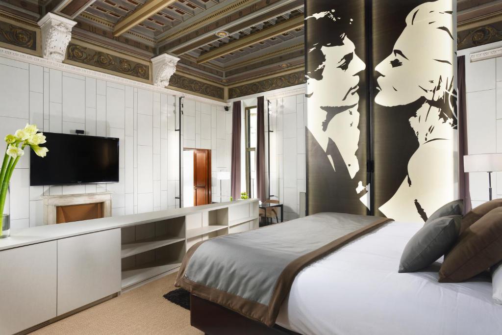 a hotel room with a bed and a television at Piazza Del Gesu' Luxury Suites in Rome