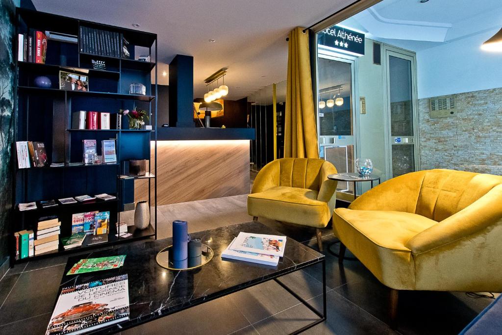 a living room with two chairs and a table at ATH hôtel Athénée in Cannes