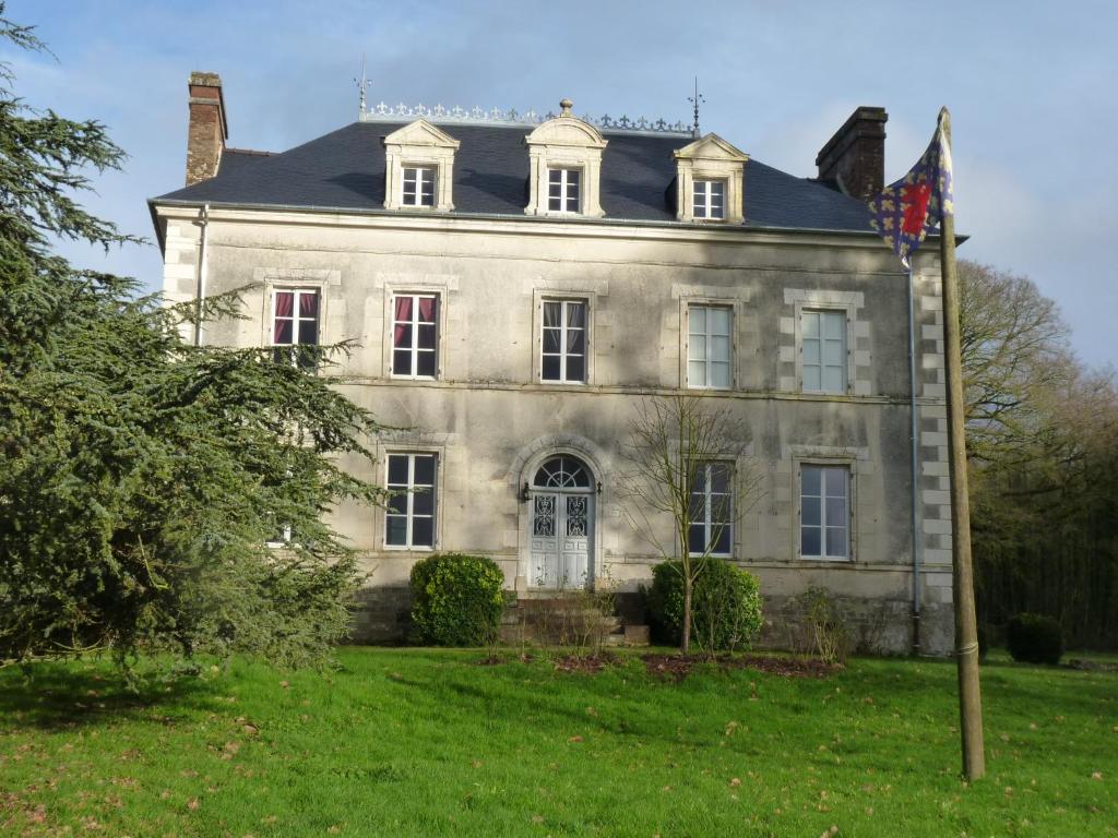 ein altes Haus mit einer Flagge davor in der Unterkunft chateau de Craon in Comblessac