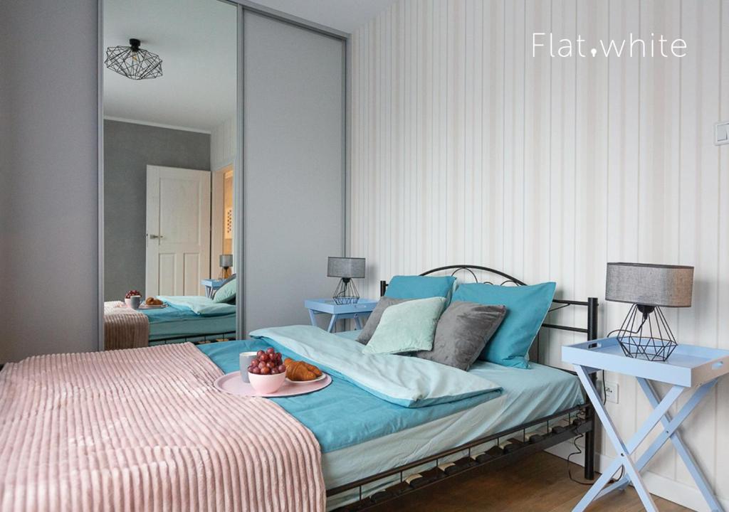 a bedroom with a bed with a plate of fruit on it at Apartamenty Flat White Zamkowa 4-6 in Zielona Góra