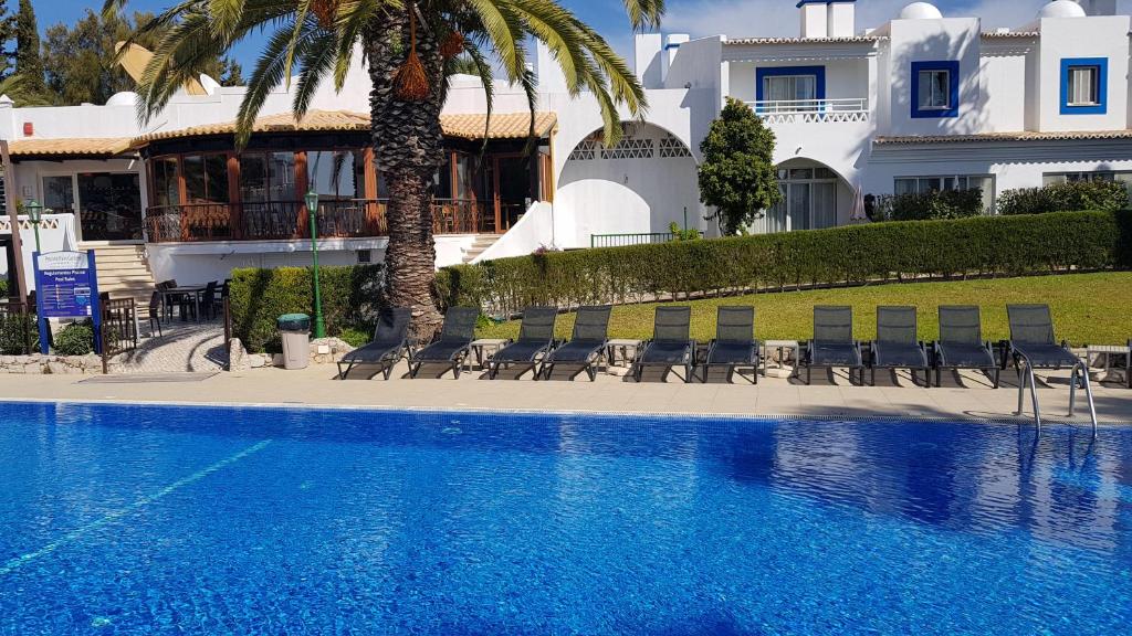 a swimming pool in front of a house at Pestana Palm Gardens in Carvoeiro