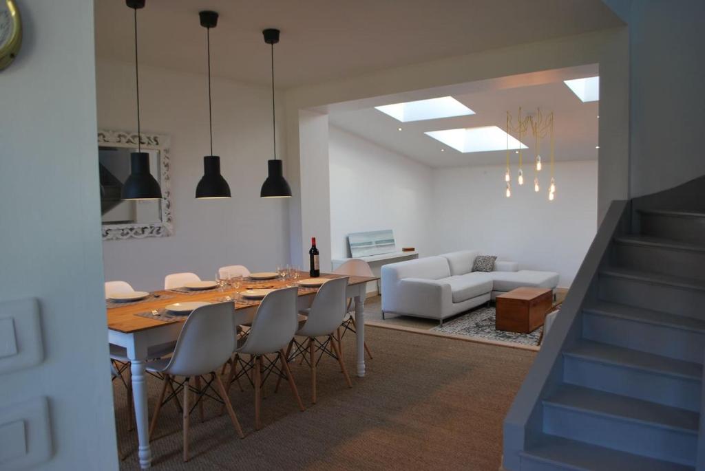 a dining room and living room with a table and chairs at Maison de village, charme scandinave in Carantec