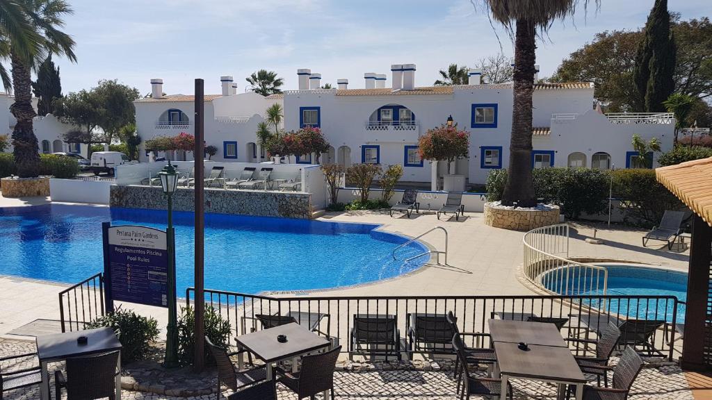 a resort with a pool and tables and chairs at Pestana Palm Gardens in Carvoeiro