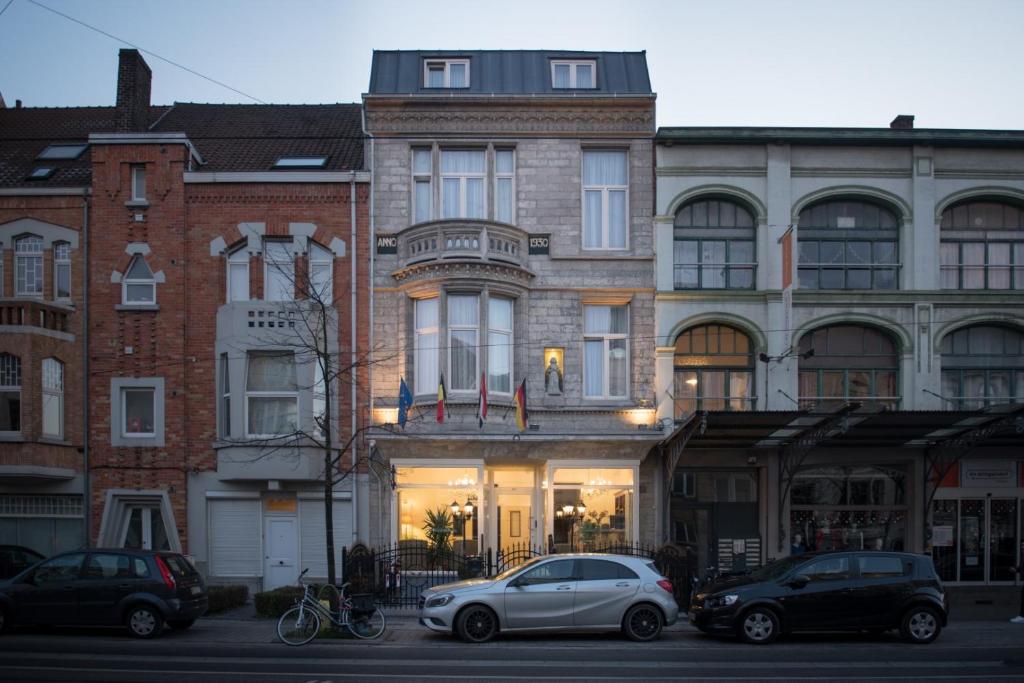 a building with cars parked in front of it at Hotel The Lord in Ghent