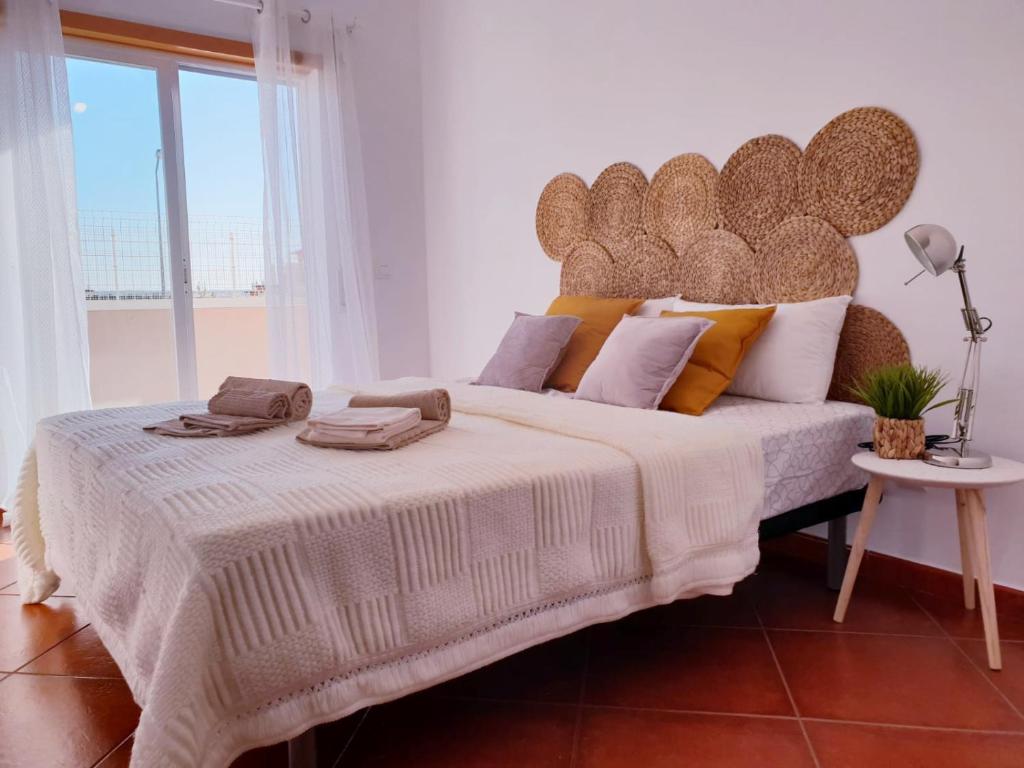 a bedroom with a large bed with a large headboard at Quinta dos Arcos Feel At Home in Armação de Pêra