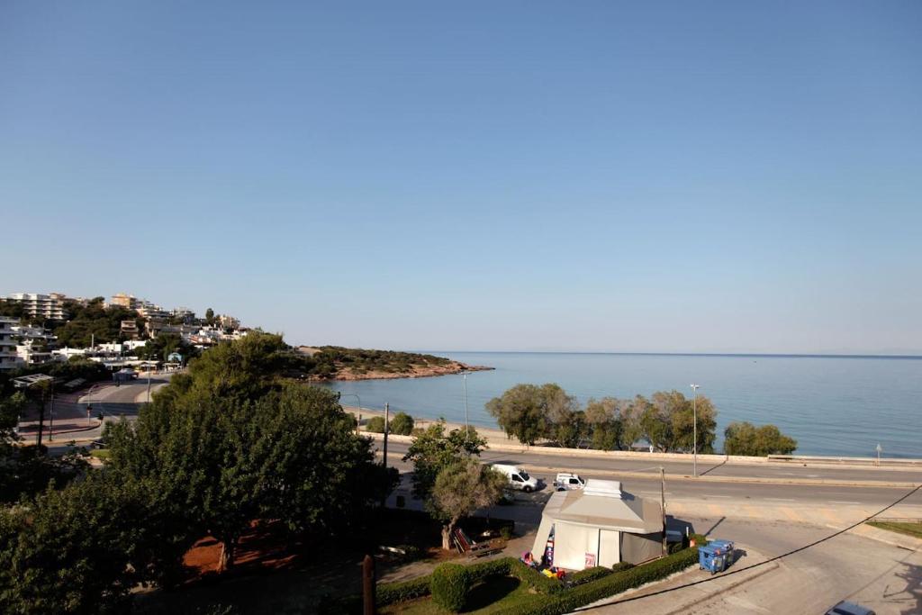 - une vue sur la plage avec une tente blanche et l'eau dans l'établissement Seaside Renovated Top Floor Apartment, à Saronida