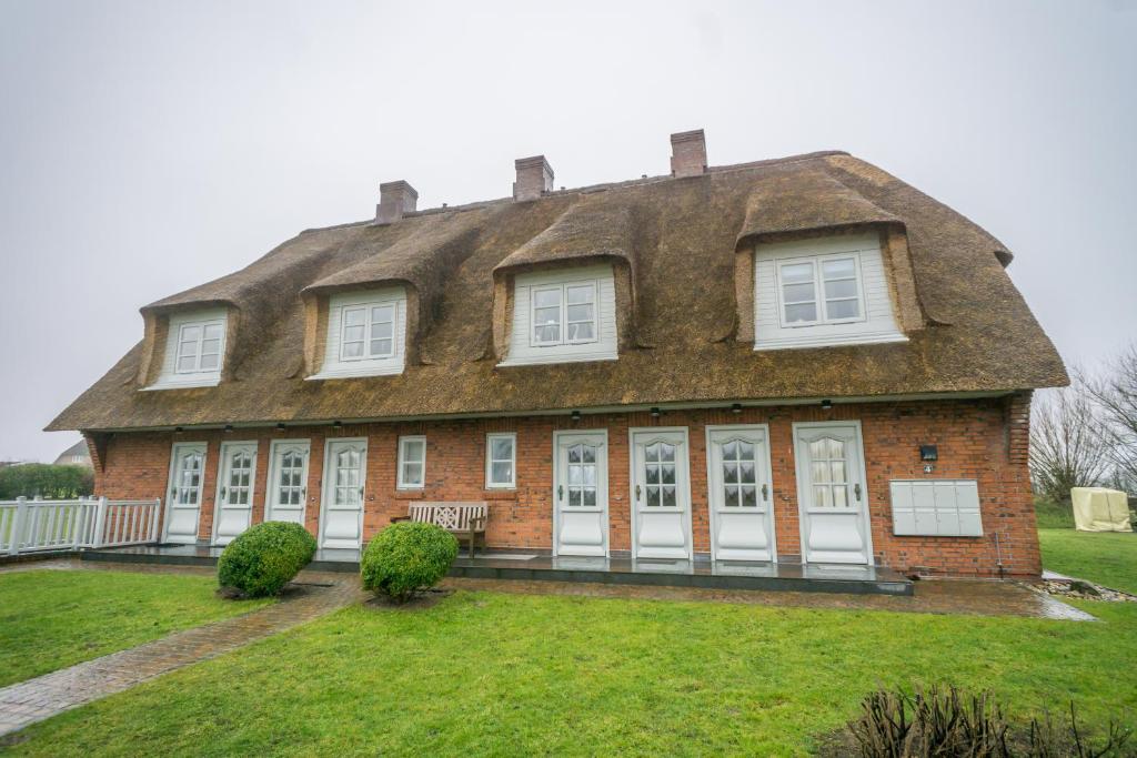 Cette grande maison en briques est dotée d'un toit de chaume. dans l'établissement Watthüs OG, à Morsum