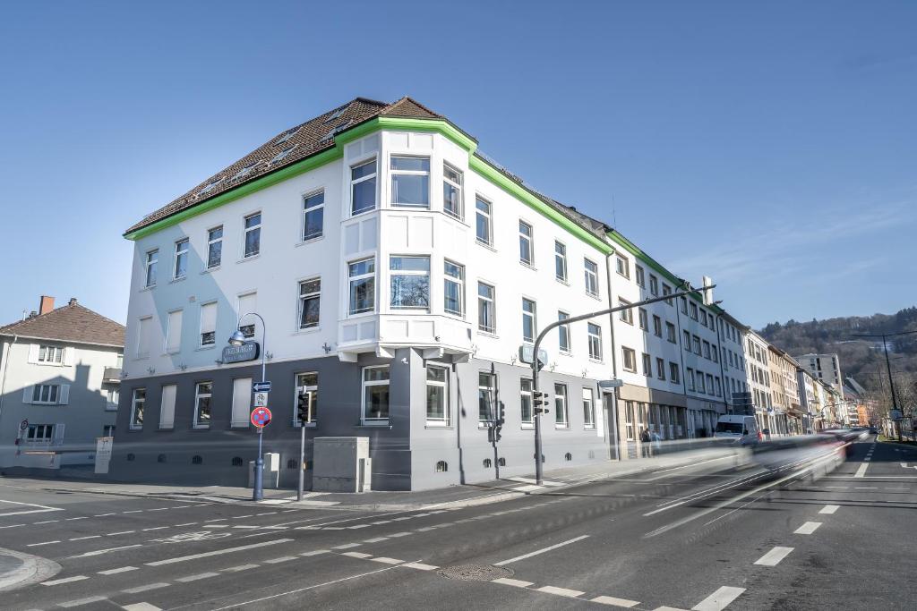 ein weißes Gebäude an der Ecke einer Straße in der Unterkunft Freiburg Apartments Friedrichring in Freiburg im Breisgau
