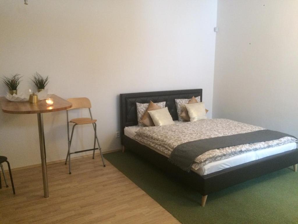 a bedroom with a bed and a table in it at Dragonfly in Brno