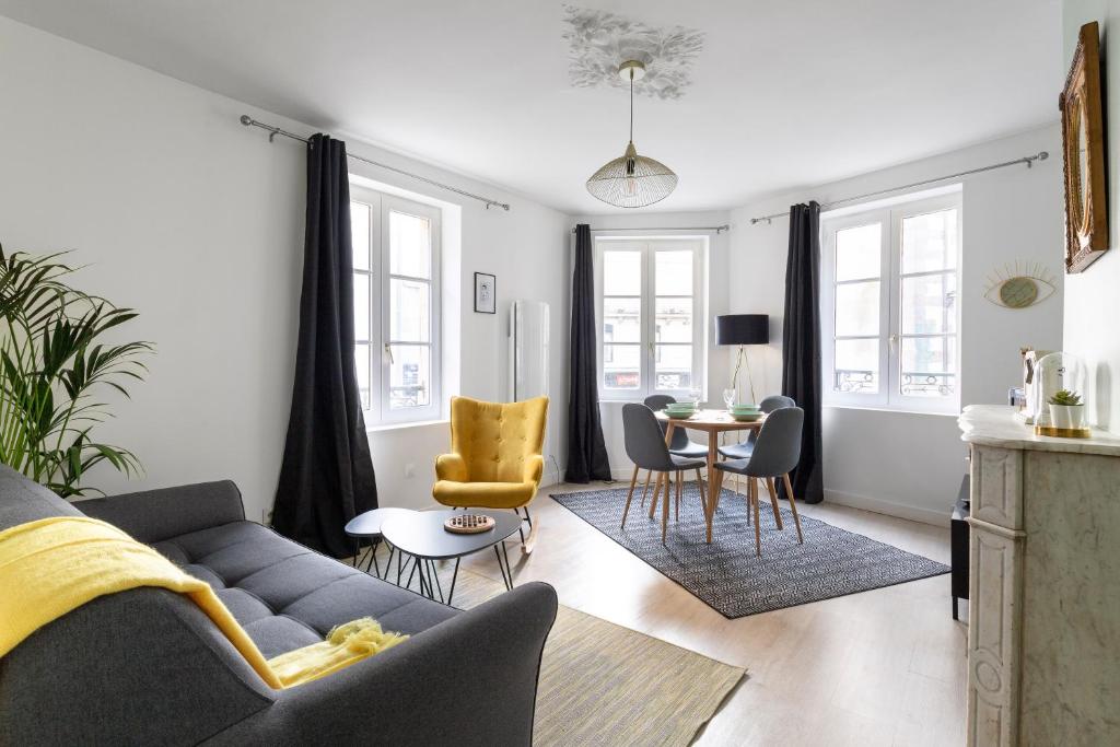 ein Wohnzimmer mit einem Sofa und einem Tisch in der Unterkunft LE CRAZY by Cocoonr in Rennes