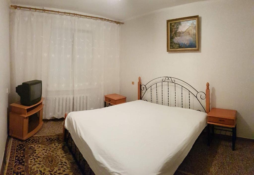 a bedroom with a bed and a tv and a window at Apartment on Y. Mudroho 44 in Bila Tserkva