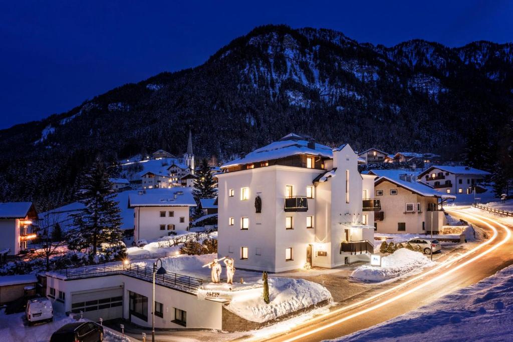 a town at night with a mountain in the background at Alpin Sport in Ortisei