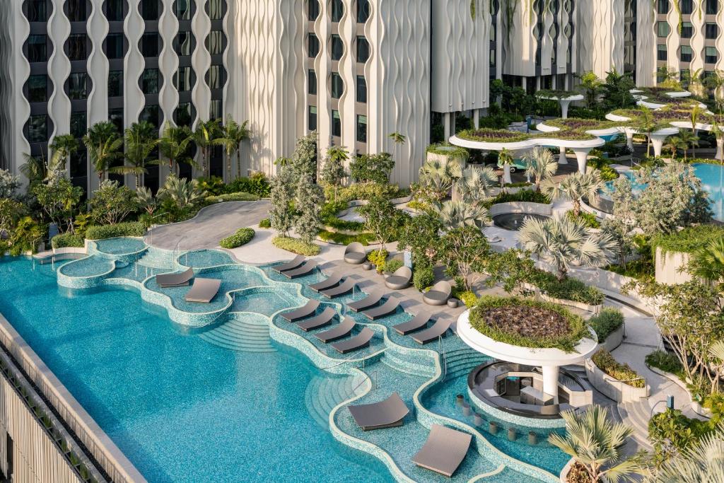 an aerial view of a resort pool with lounge chairs at Village Hotel Sentosa by Far East Hospitality in Singapore