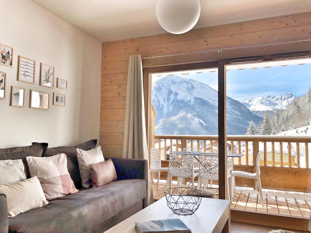 a living room with a couch and a view of a mountain at ALPA appartements - Champagny-en-Vanoise in Champagny-en-Vanoise