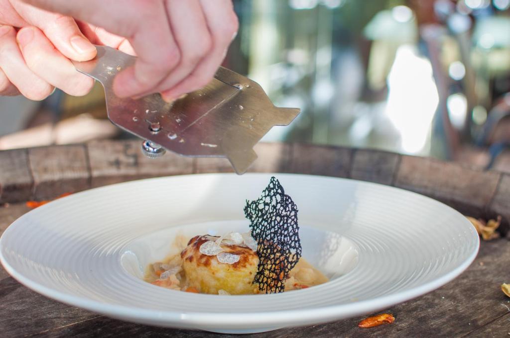 a person is pouring sauce onto a plate of food at Hotel Marina in Izola