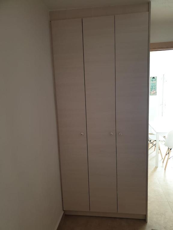 a room with white cabinets and a white wall at Maya Apartments in Dexamenes