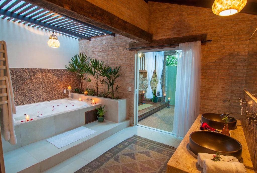 a bathroom with a large tub and a large window at Estalagem Wiesbaden in Monte Verde