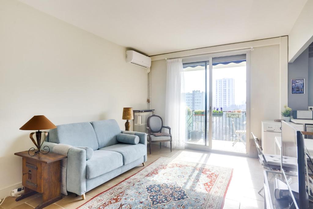 a living room with a blue couch and a sliding glass door at Charming apartment with terrace by Weekome in Paris