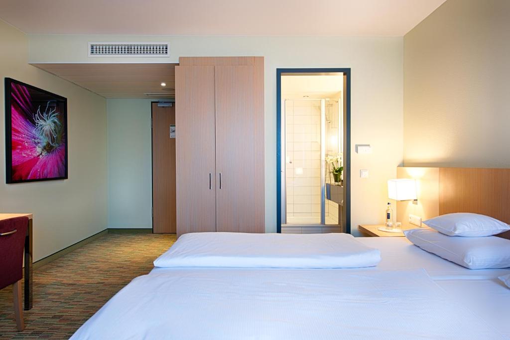 Postel nebo postele na pokoji v ubytování Welcome Hotel Paderborn