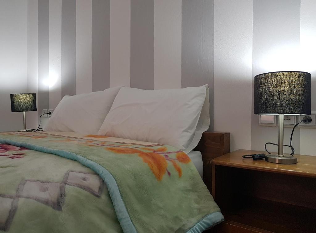 - une chambre avec un lit et deux lampes sur une table dans l'établissement AYLI HOUSE, à Essaouira