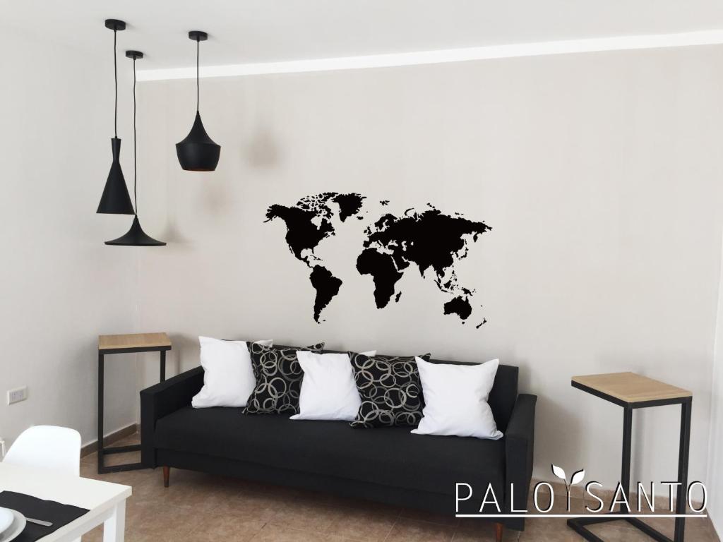 a living room with a black couch with a world map on the wall at Palo Santo Dptos. in Chilecito