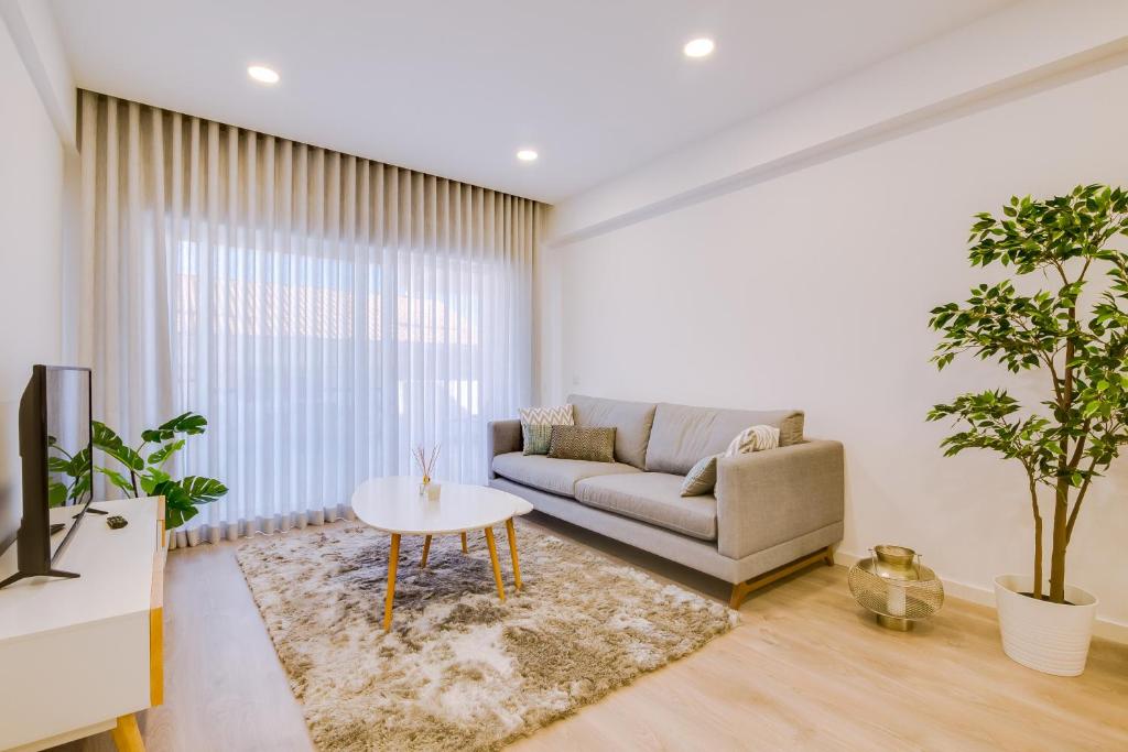 ein Wohnzimmer mit einem Sofa und einem Tisch in der Unterkunft Ella - Fantastic apartment - Vilamoura in Vilamoura