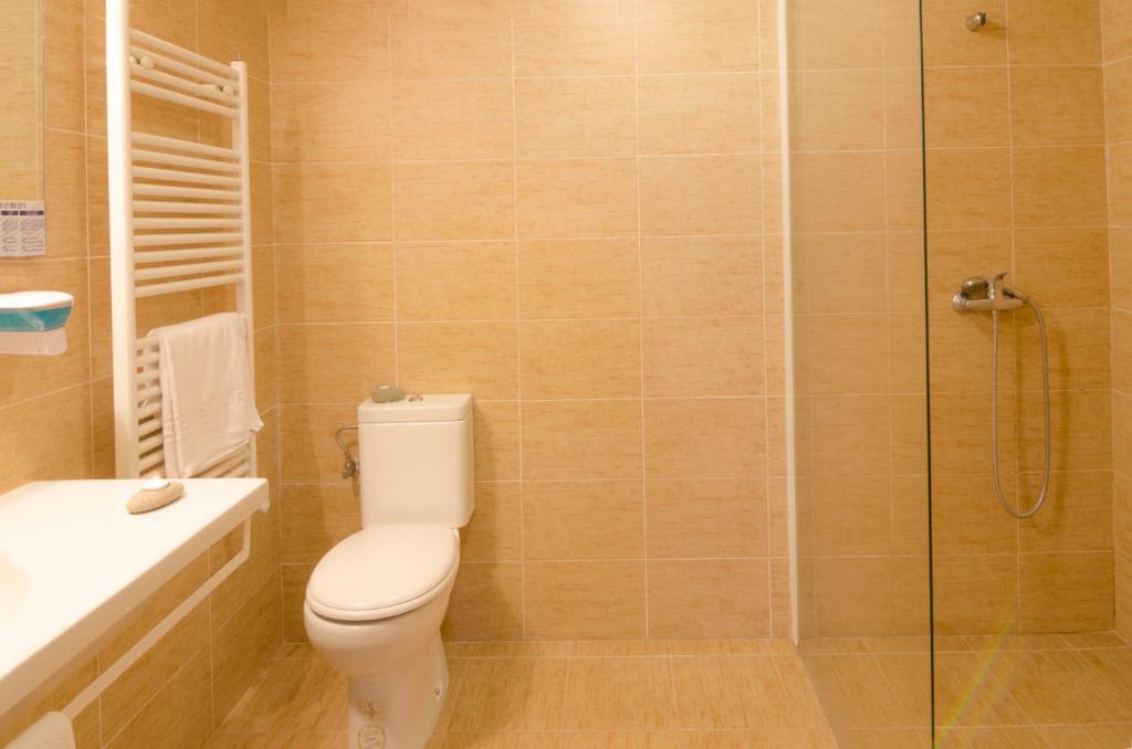 Un baño con inodoro y ducha de cristal. en Hotel Arha Potes & Spa, en Potes