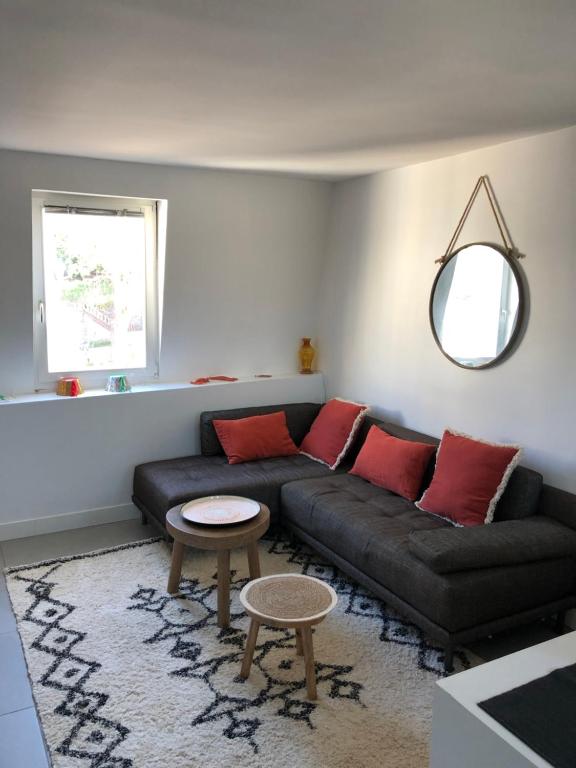 a living room with a black couch and red pillows at L'étoile de Trouville in Trouville-sur-Mer